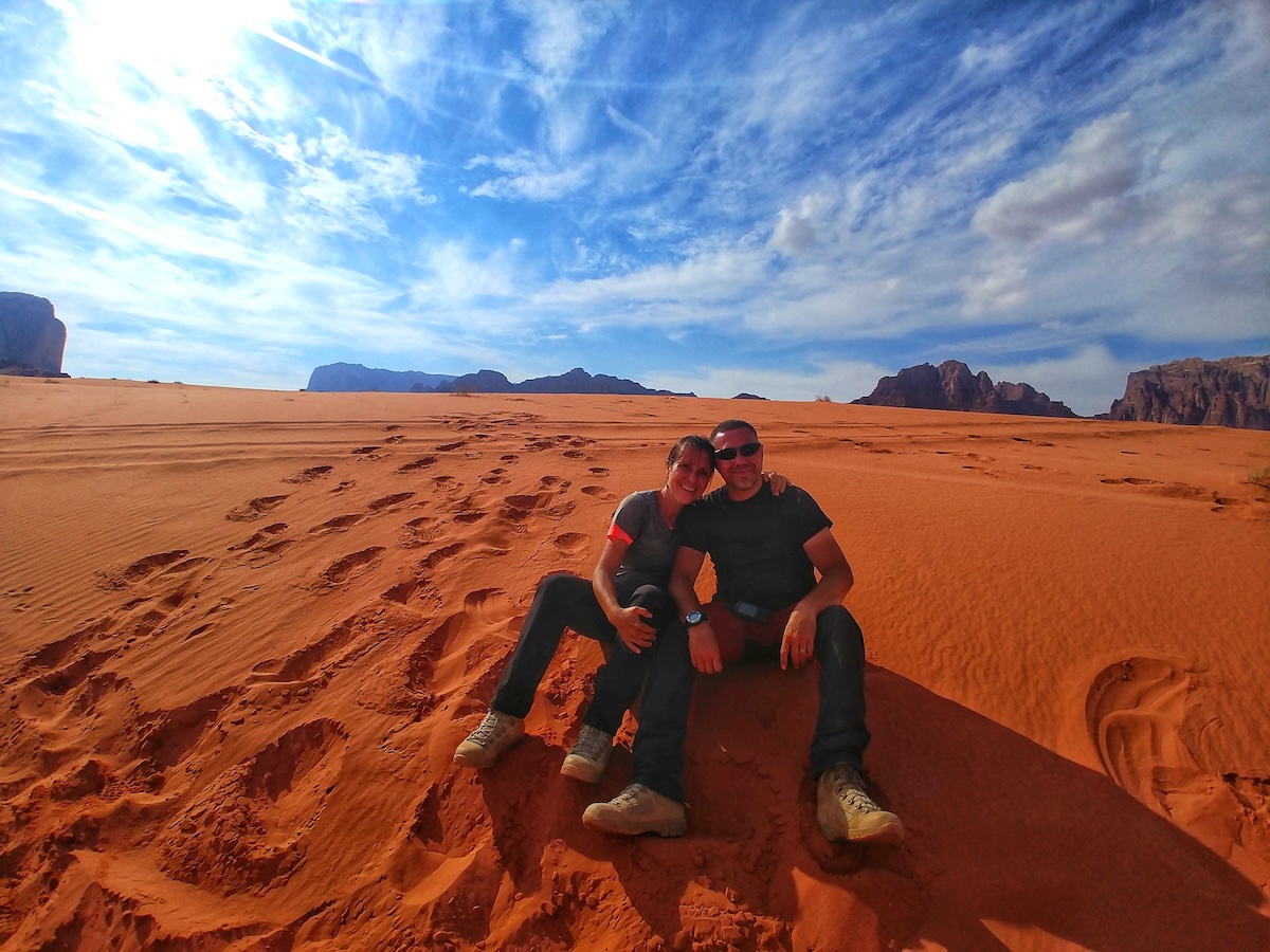 Laura seduta sulle dune rosse del deserto di Wadi Rum durante il Jordan Trail